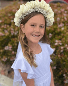 a little girl wearing a flower crown and a veil