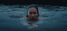 a woman is swimming in a body of water .