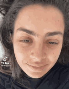 a close up of a woman 's face without makeup and smiling .