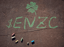 the word zenzc is written in green chalk on a brown surface