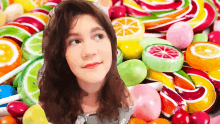 a girl is standing in front of a pile of candy