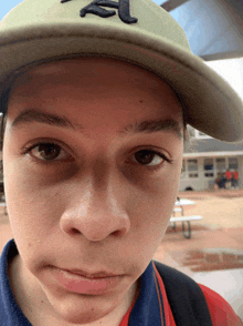 a young man wearing a green hat with the letter a on it