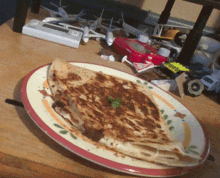 a plate of food sits on a wooden table surrounded by toy planes