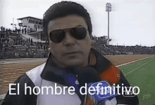 a man wearing sunglasses and a microphone with the words el hombre definitivo written on it