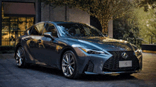 a grey lexus is parked in front of a brick building