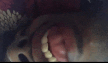 a close up of a person 's mouth with teeth and a snake coming out of it .