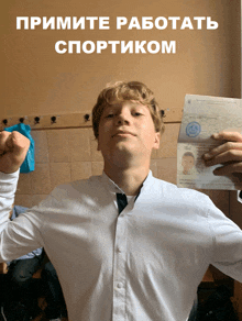 a boy in a white shirt and tie is holding a passport in front of a sign that says " примите работать спортиком "