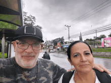 a man and a woman are posing for a picture in front of a billboard that says ' coca cola '