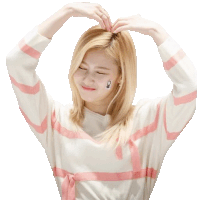 a woman wearing a pink and white striped sweater is making a heart shape with her hands