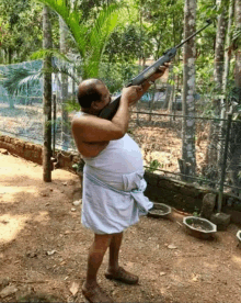 a man in a white towel is holding a rifle that says ' sniper ' on the front