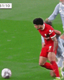 a soccer player with the number 2 on his shorts is trying to tackle another player