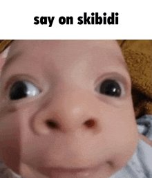 a baby is making a funny face with the words `` say on skibidi '' written above it .