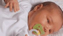 a baby is laying down with a pacifier in its mouth