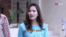 a woman wearing a blue shirt that says tiffany jane on it