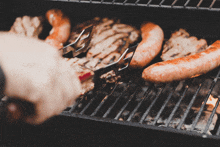 a person is grilling meat on a grill with tongs