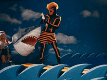 a man in a striped shorts is spraying a shark with a spray bottle