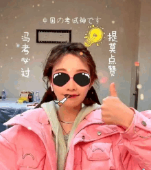 a woman wearing sunglasses and a pink jacket gives a thumbs up sign