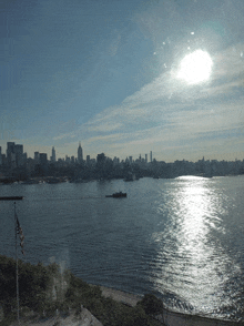 the sun shines brightly over a body of water with a city in the background