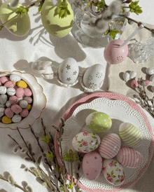 a table with pink and green easter eggs and candy