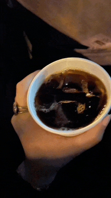 a woman holding a cup of coffee in her hand