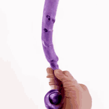 a person is holding a purple object that looks like an octopus