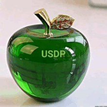 a green glass apple with the word usdr on it