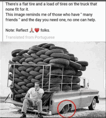 a man is sitting in the back of a truck with a load of tires on the back .