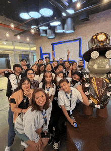 a group of people posing for a picture with a statue of a frog