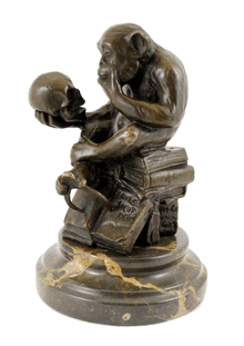 a statue of a monkey holding a skull on top of a pile of books with the word deus on them