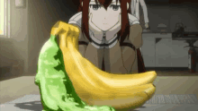 a girl is kneeling down next to a banana and a green banana on a table .