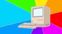 a computer is sitting in front of a rainbow colored background .