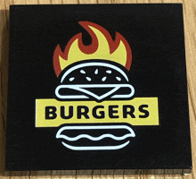 a black sign that says burgers with a flaming hamburger