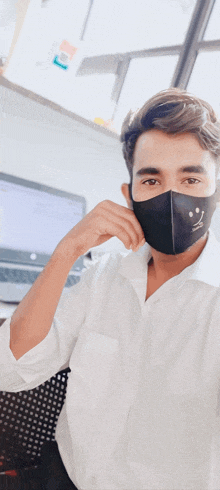 a man wearing a face mask with a smiley face drawn on it