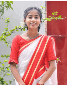 a woman wearing a red and white striped blouse is smiling