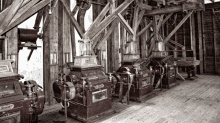 a black and white photo of a row of machinery including one that says ' schneider ' on the front