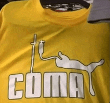 a yellow coma t-shirt with a cat and a cross on it