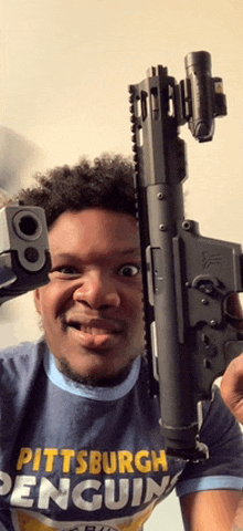 a man wearing a pittsburgh penguins shirt holds a gun