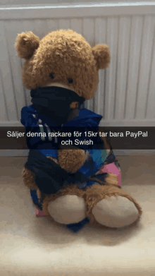 a teddy bear with a scarf around its neck and paypal and swish written on the bottom right