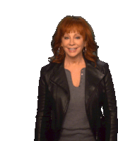 a woman with red hair is wearing a black jacket