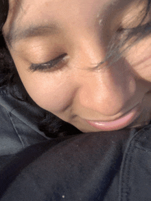 a close up of a woman 's face with a black shirt behind her