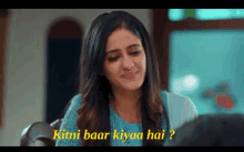 a woman sitting at a table with the words kitni baar kiyaa hai written on the bottom