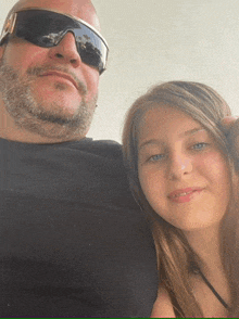 a man with a beard and sunglasses poses with a young girl