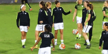 a group of women are playing soccer on a field and one of them is wearing a usa jersey .