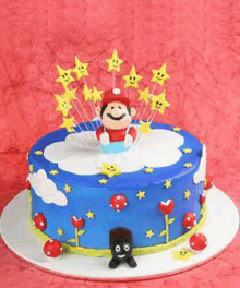 a blue cake with a monkey sitting on a cloud and stars on top .