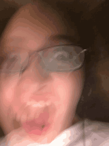 a blurry picture of a person wearing glasses and making a funny face