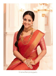 a woman wearing a red saree and gold jewelry is photographed by g.venket ram