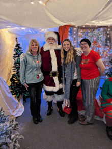 a woman in a red shirt that says ' christmas ' on it poses with santa