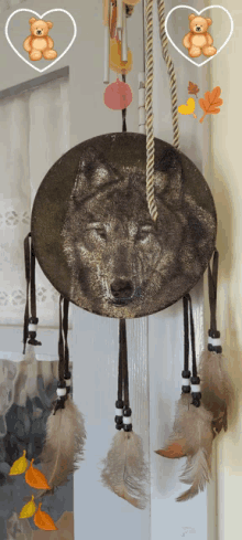 a dream catcher with feathers and a picture of a wolf