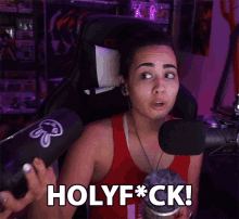 a woman in a red tank top says holyf * ck in front of a microphone