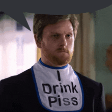 a man wearing a bib that says " drink piss "